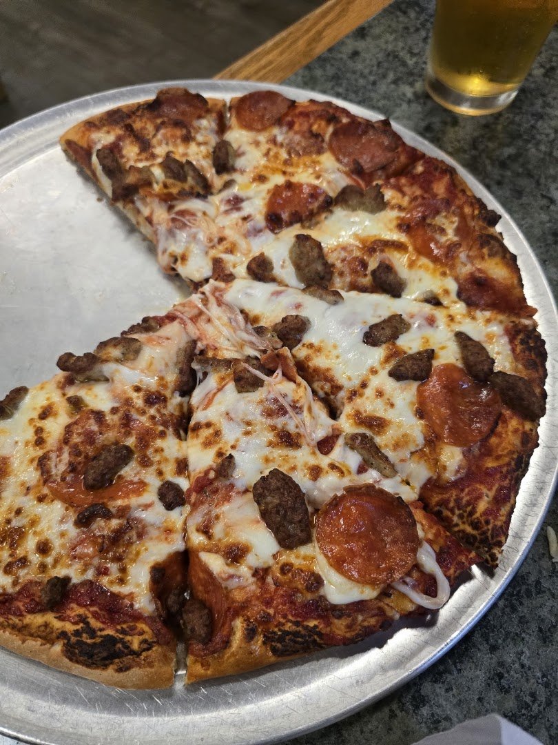 Family-style pizza spot with booths and warm lighting.